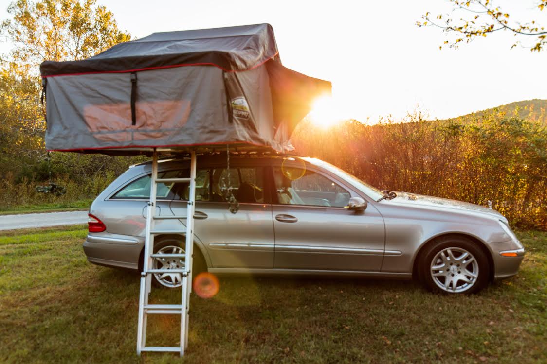 Tenda da tetto aperta su un’automobile in campeggio